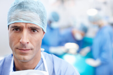 Medical, surgery and doctors with man in theatre for teamwork, operating room and emergency. Cardiology, organ transplant and portrait with person in hospital for clinic, healthcare and pride