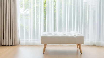 A stylish white ottoman sits elegantly in front of sheer curtains, allowing natural light to filter through, creating serene and inviting atmosphere