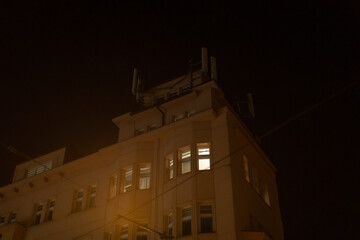 A large and impressive building with numerous windows is brightly lit up at night, creating a...