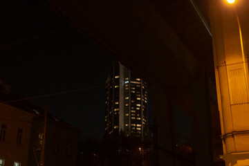 A tall building characterized by numerous windows is beautifully illuminated during the nighttime...