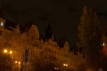 A slightly unclear and blurry picture showcasing a building amidst the night sky, featuring various...