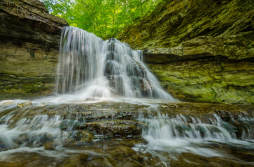 waterfall in the forest green trees rock stream between mountains 