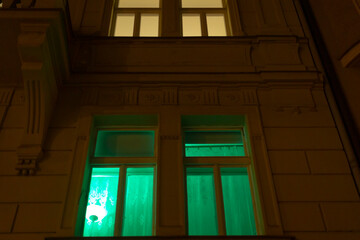 Obraz premium A large window emits a vibrant green light, casting an enchanting glow in the surrounding area, enhancing the nighttime atmosphere