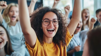 Fototapeta premium Joyful young woman celebrating with raised hands in a crowded indoor environment full of happiness and excitement