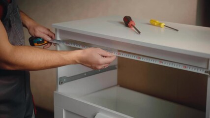 A person demonstrates assembling a drawer unit using hand tools. The process takes place in a cozy room, showing clear steps and techniques for efficient furniture assembly.