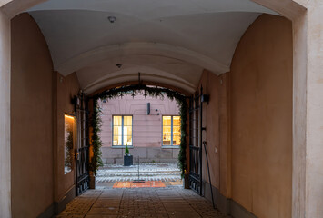 Fototapeta premium Cozy arched passageway with view of illuminated windows. 