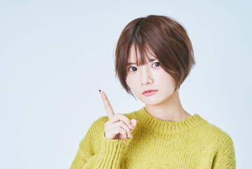 人差し指を立てるショートカットの女性