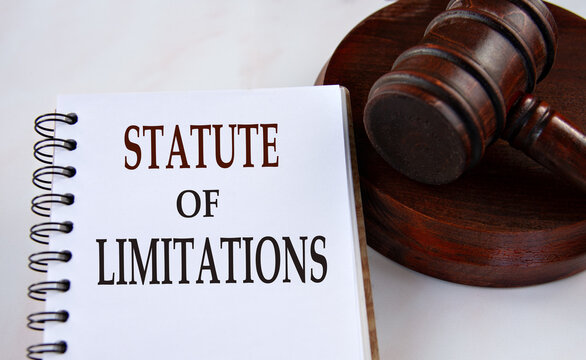 STATUTE OF LIMITATIONS - words in a white notebook with a judge's gavel in the background