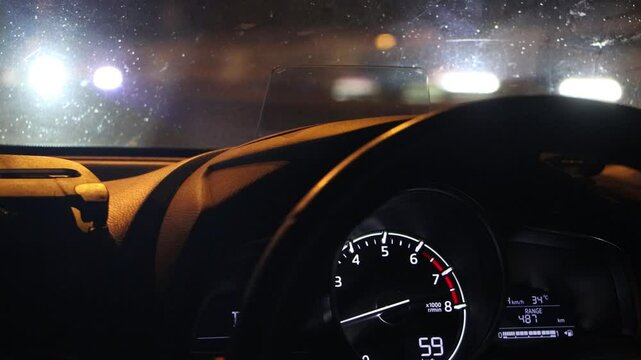View through the windshield of a car driving in the night city