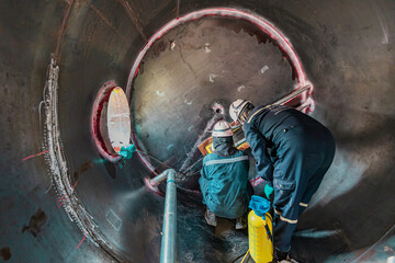 Inside male worker into the inspection shiny tank industrial construction oil and gas or storage tank oil chemical into area