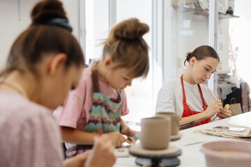 Artistic pottery class with children and adults engaged in creative activities