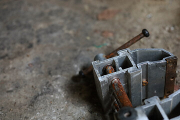 Dirty workshop floor with old, rusty, vice lying on it