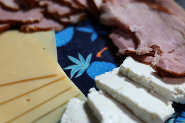 Close up of the colorful plate full of cheese and ham slices
