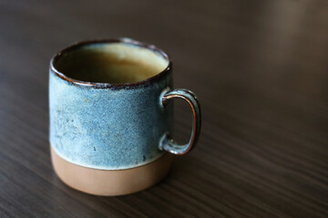 Beautifu,l handmade, turquoise ceramic mug on the dark wood table
