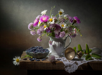 Still life with a bouquet of wild flowers and honeysuckle on a dark background