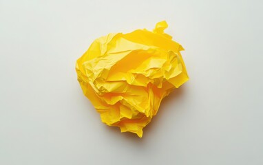 A crumpled yellow paper arranged in the shape of a light bulb on a white background, symbolizing creativity and innovation. 