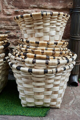 Stacked handcrafted wicker baskets with intricate patterns displayed on a rustic outdoor setting in Ezcaray, Spain