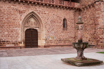 Santa María la Mayor fortress-church with Gothic architecture and a historic fountain in Ezcaray, Spain