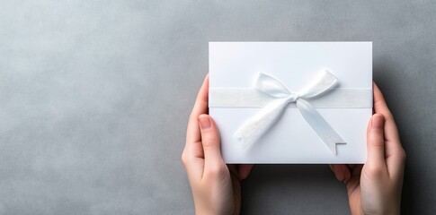Obraz premium Blank White Paper with Gift Ribbon Bow in Women's Hands