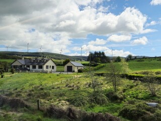 House with Window Surrounded by Trees and Grass Under Cumulus Clouds in Natural Landscape © Studio-M