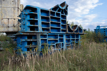 Abandoned Industrial Machinery Overgrown with Grass in Rural Landscape