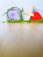 Advent hope peace joy love text on paper with wreath, cross, heart with copy space background. Advent season for Christmas preparation concept.