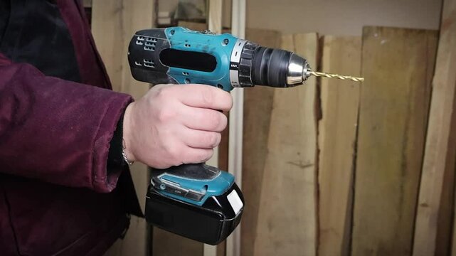 Male hands working with drilling machine in workshop