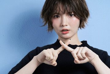 拒絶のポーズをするショートカットの女性
