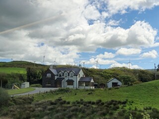 Landscape View of a House with a Tree and Cloudy Sky © Studio-M