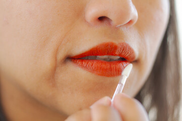 Naklejka premium Women's makeup. Latin woman painting her lips. Painted lips. Lip paint.