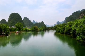 Green mountains and cloudy sky reflecting in Yangshuo River, Sichuan, China