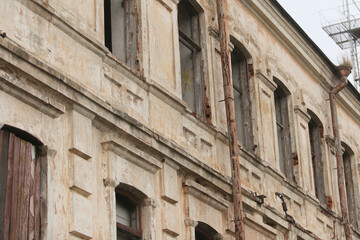 Obraz premium The wall of an abandoned house with empty, broken windows