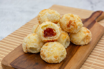 Delicious Brazilian cheese bread filled with sweet goiabada on a wooden board.