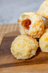 Close-up of Brazilian cheese bread with goiabada filling on a wooden board.