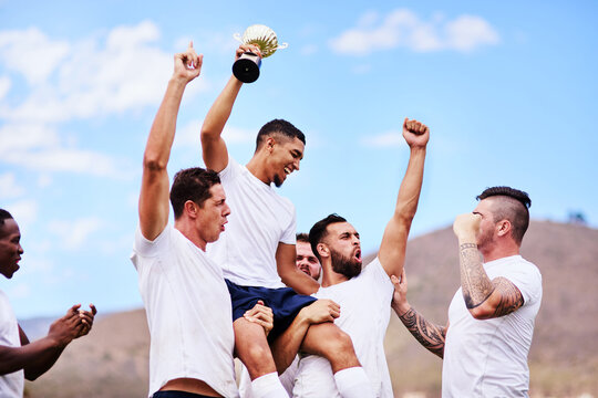 Happy men, celebration and sport team with trophy for victory, accomplishment or competition in nature. Male people, athletes or rugby players with smile for winning award, championship or game