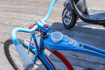 A Chopper Bicycle in blue and red with a cupholder in the frame