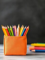 Fototapeta premium Vibrant Colorful Pencils in Organizer - A bright orange pencil holder filled with assorted colored pencils ready for artistic creativity and learning.