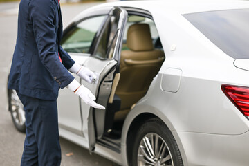 車の後部ドアを開ける運転手