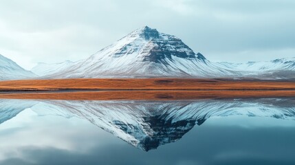 Majestic snow-capped mountain reflected in a calm lake.