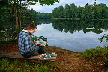 Young artist painting a serene lake scene with watercolors
