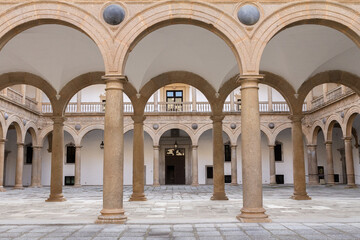 Fototapeta premium Elegant columns of the Hospital de Tavera in Toledo, Spain, showcasing Renaissance architecture with intricate detailing and classical style. 