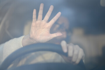 車を運転しながら驚く男性