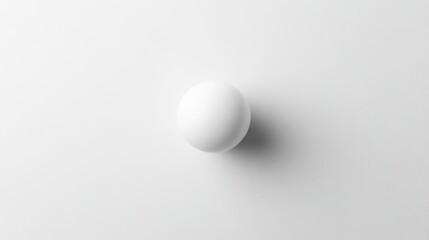 Minimalist top view of a smooth white sphere casting a subtle shadow on a pristine white background for modern design concepts.