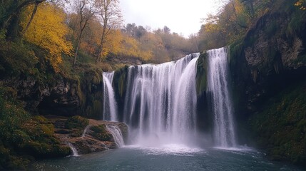 Fototapeta premium Multi-tiered waterfall in the Aragonese Pyrenees surrounded by vibrant autumn foliage reflecting tranquility and dynamic water flow
