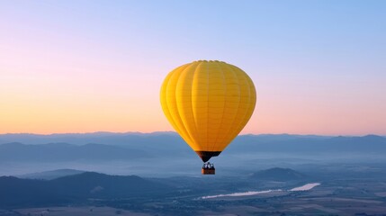 Obraz premium A vibrant yellow hot air balloon soaring over a serene landscape.