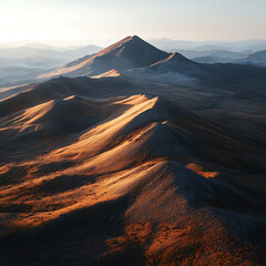 Breathtaking Aerial View of Deserted Mountain Range with Warm Sunset Light Casting Shadows on Golden Hues of Sand and Rocky Terrain in Remote Wilderness Landscape