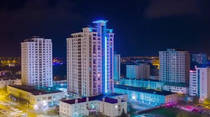 Obraz premium A vibrant night view of modern high-rise buildings illuminated with colorful lights.