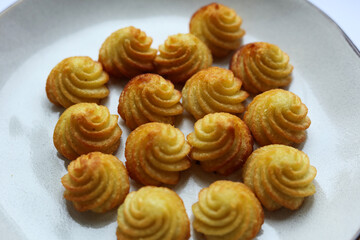 potato kisses on a white plate, close-up.