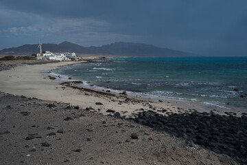 Pueblo de casas blancas tradicionales junto a la costa, en un día de climatología adversa (se...