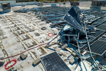Top view of destroyed by hurricane Ian photovoltaic solar panels mounted on industrial building...